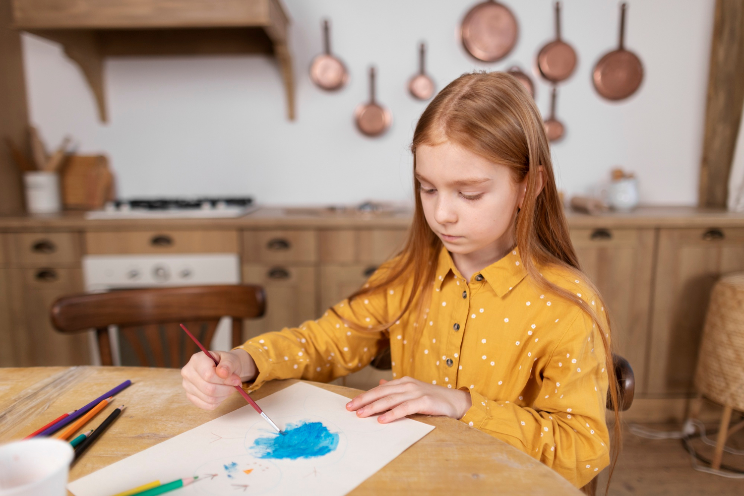 A girl painting on a sheet of paper | Source: Freepik