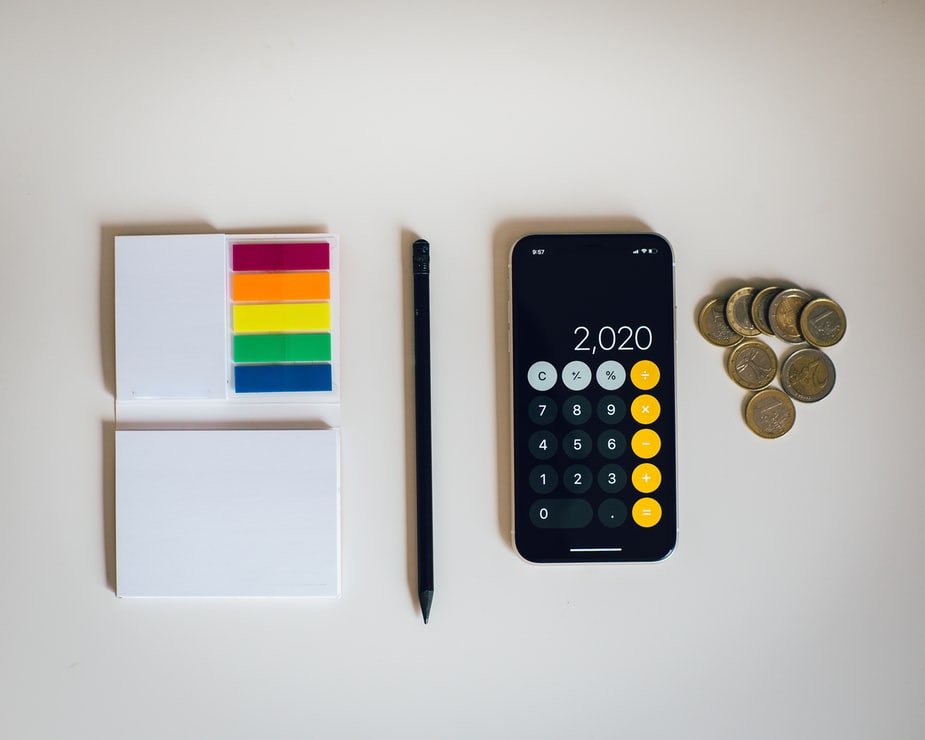Des posts-its, un crayon, une calculatrice et des pièces. l Source : Unsplash