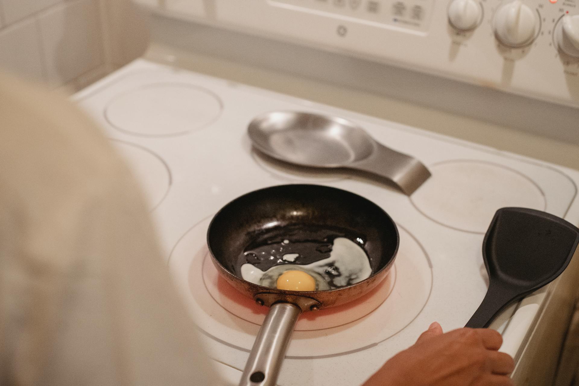 A person frying an egg | Source: Pexels