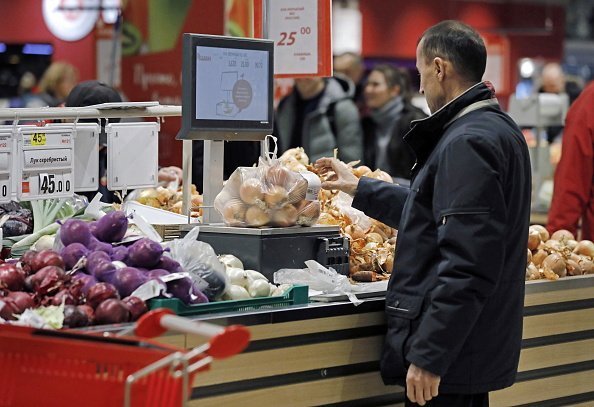 A man pictured shopping for onions in a grocery store | Photo: Getty Images