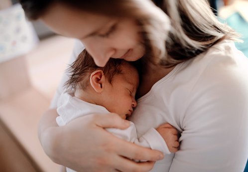 A young woman cuddling her baby with love | Photo: Getty Images