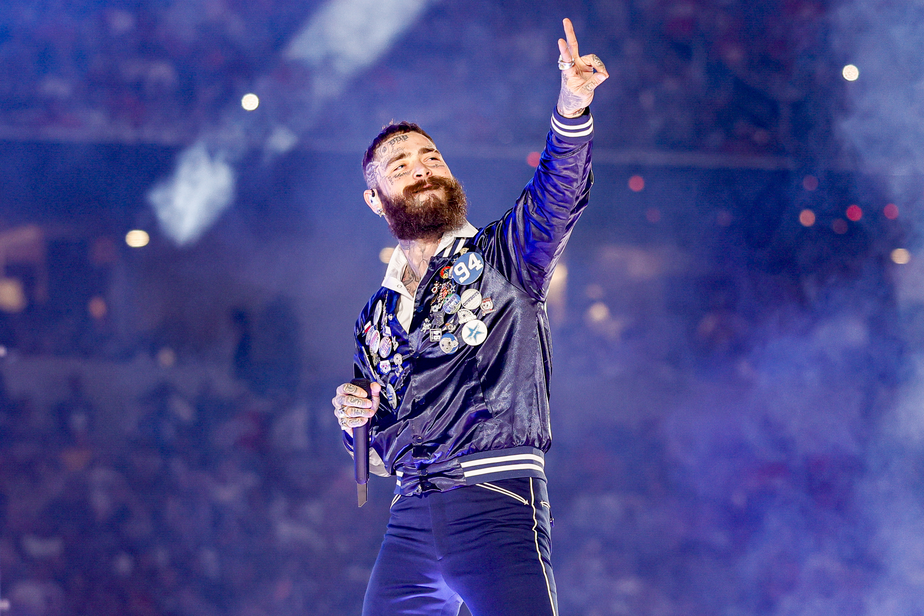 Post Malone flashes a peace sign while smiling at the crowd during his halftime performance in Texas on November 27, 2025 | Source: Getty Images