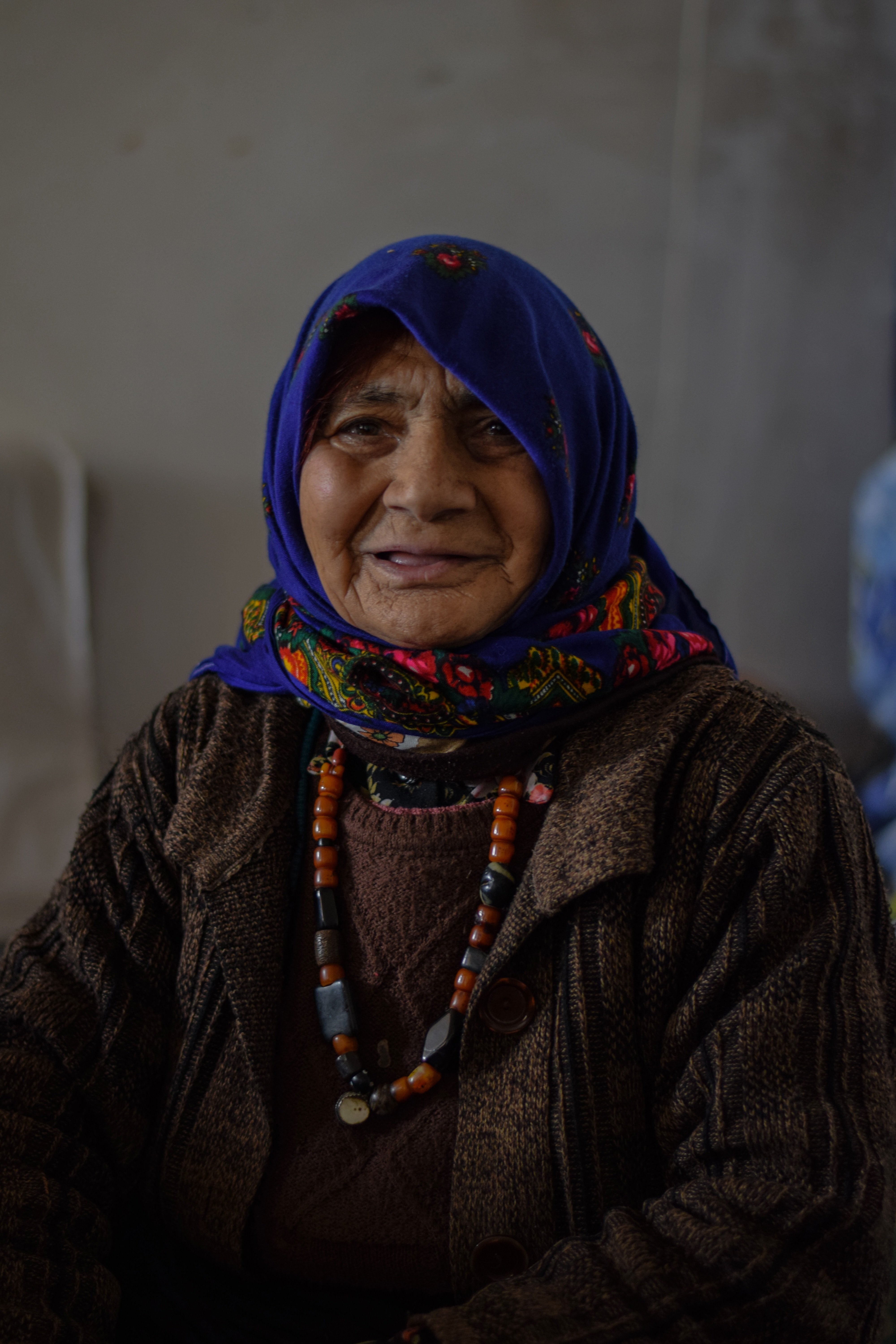 An old woman wearing a blue scarf. | Source: Unsplash