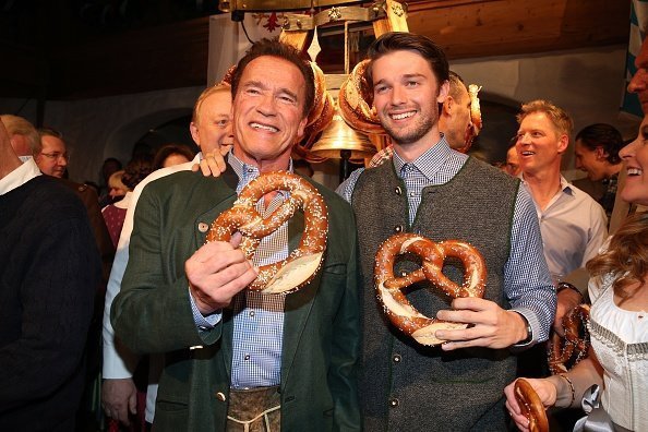 Arnold Schwarzenegger et son fils Patrick Schwarzenegger lors de la 27e Weisswurstparty à l'hôtel Stanglwirt. | Photo : Getty Images