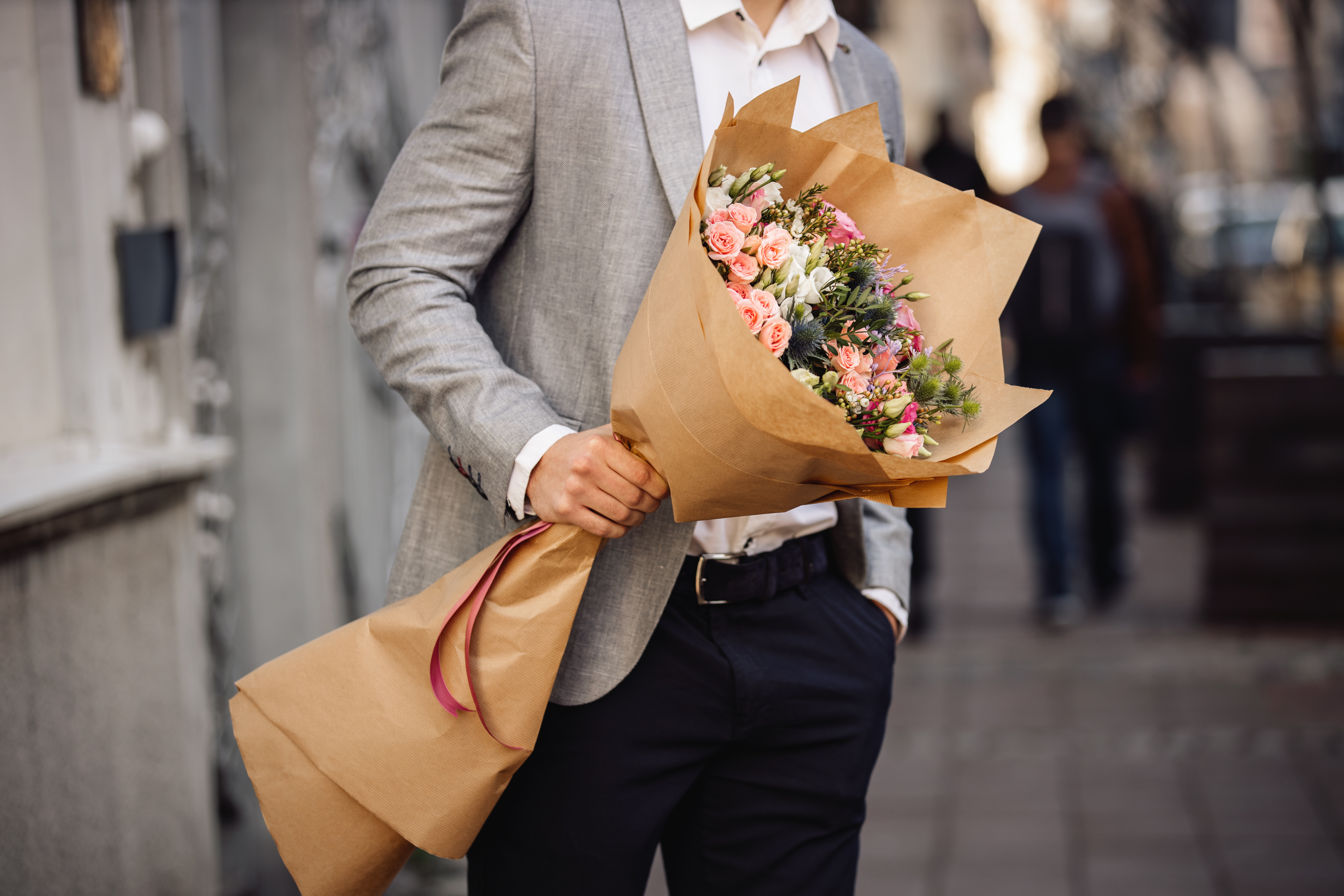 Hombre joven que sostiene hermoso ramo de flores frescas | Fuente: Getty Images