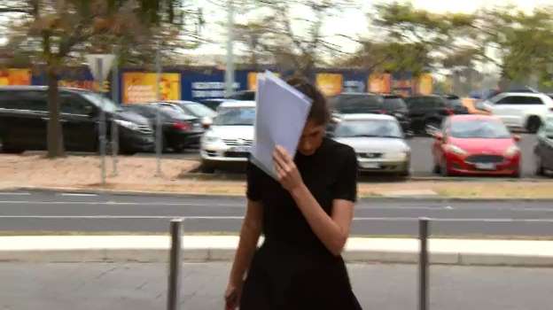 Alysha Goring se cubre el rostro al llegar a la corte. | Foto: YouTube/A Current Affair