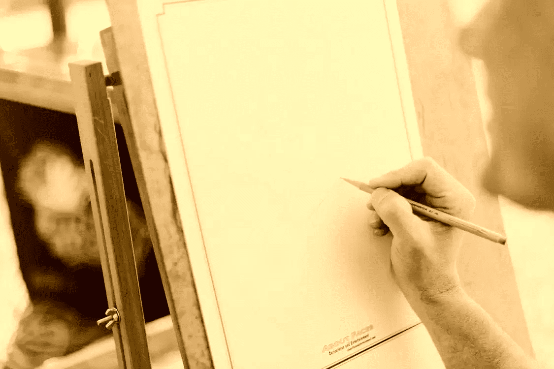 Un hombre sosteniendo un lápiz sobre una hoja en un caballete. | Foto: Pexels