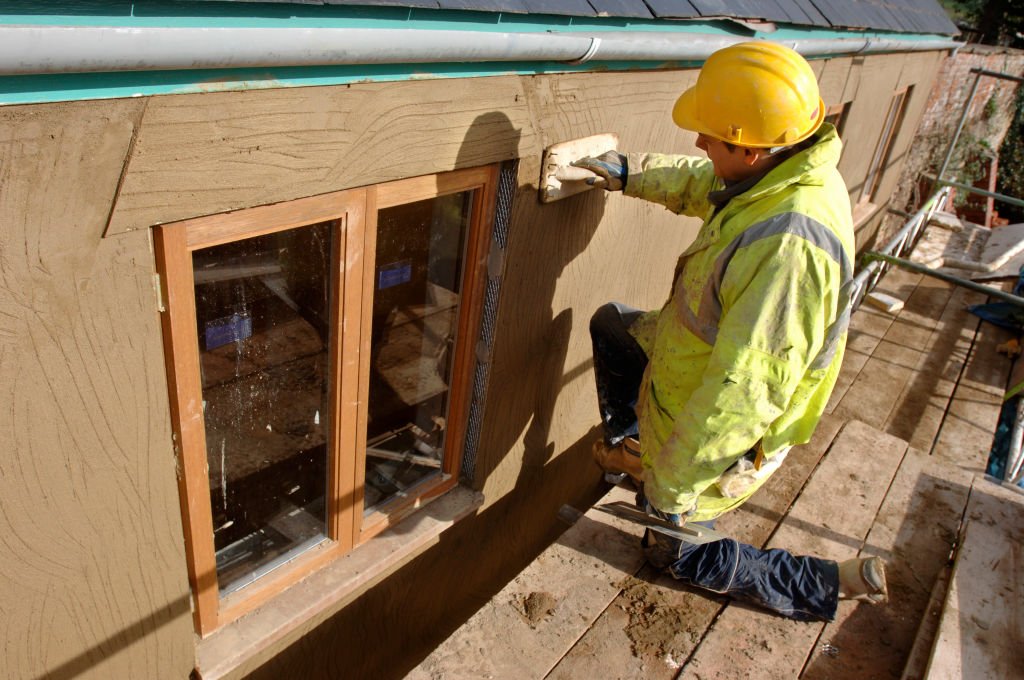 Un technicien qui travaille sur la fenêtre d'une maison. | Photo : Getty Images