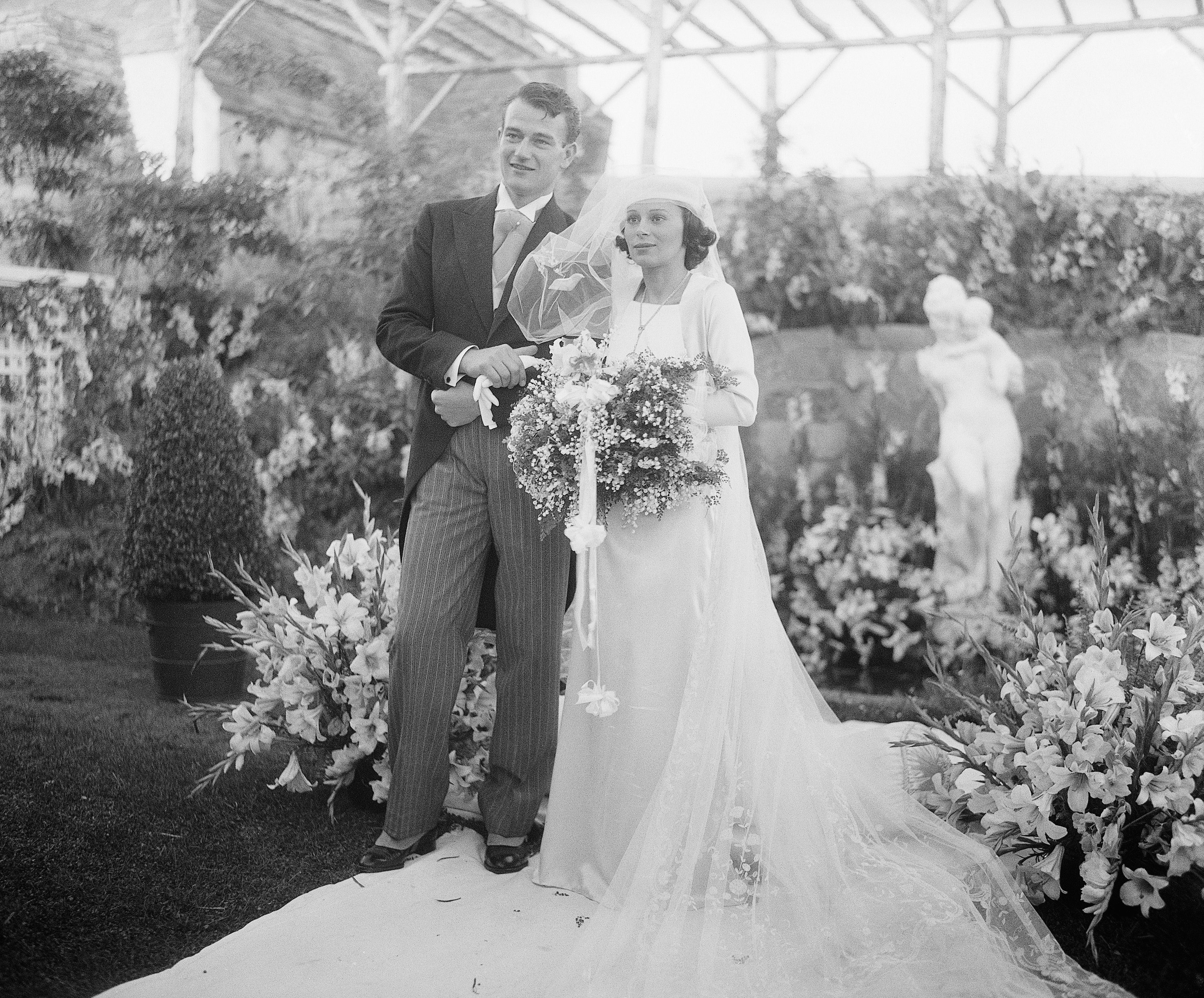 John Wayne, motion picture actor, and his bride, the former Miss Josephine Saenz, daughter of Dr. Jose Saenz, Panamanian Counsul in Los Angeles,| Source: Getty Images