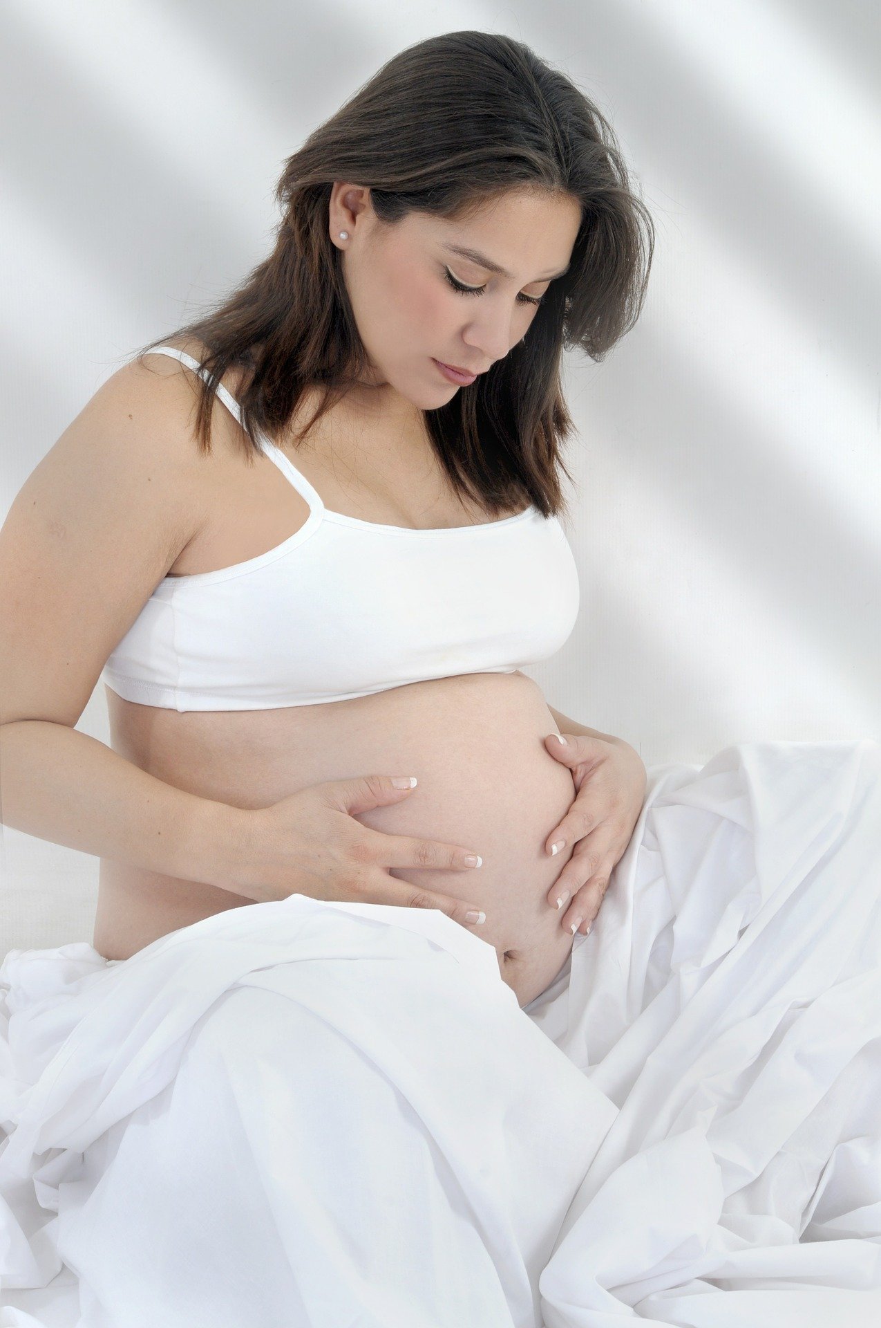 Une femme tenant son ventre | Photo : Pixabay