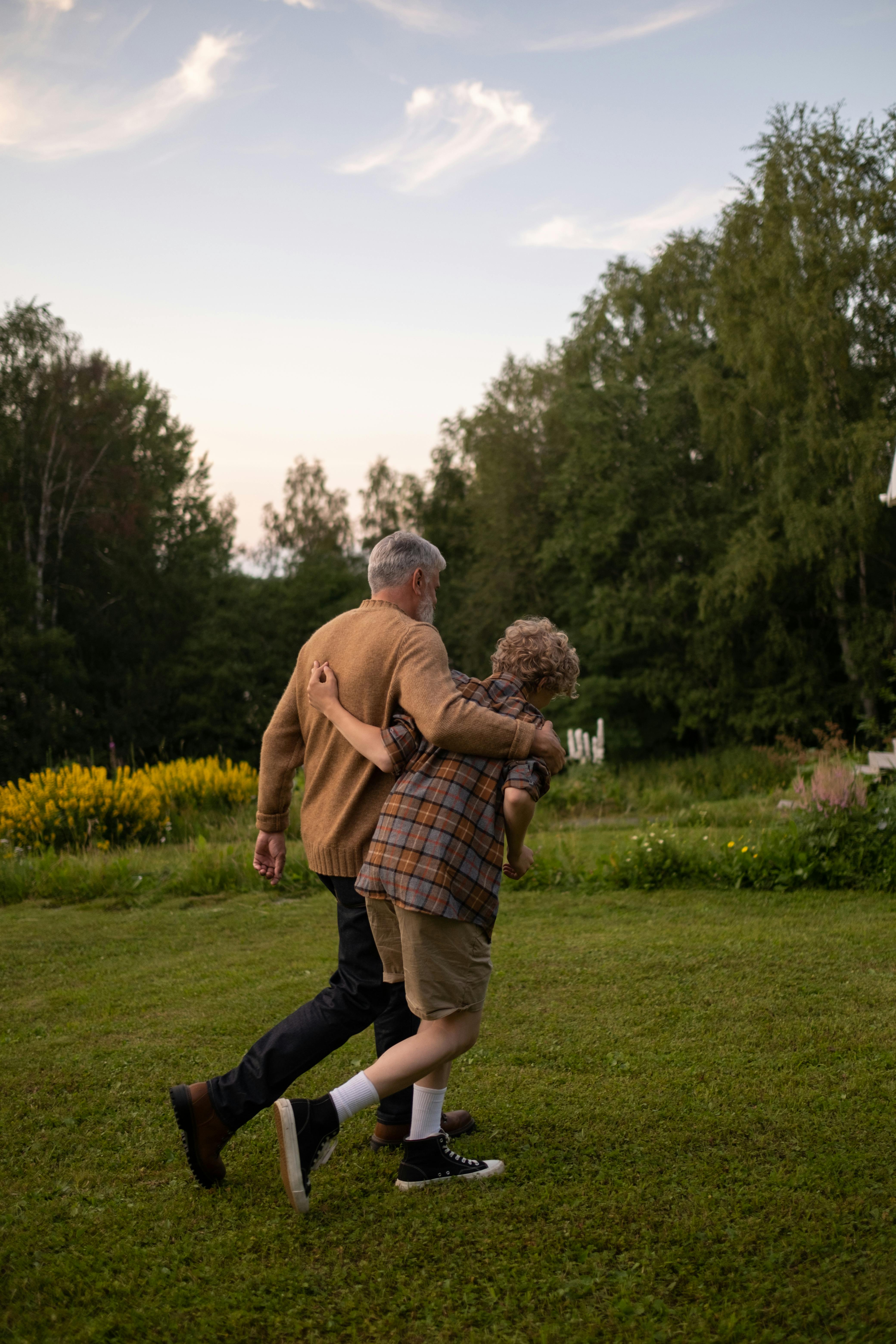 Grandfather and grandson walking in a garden | Source: Pexels