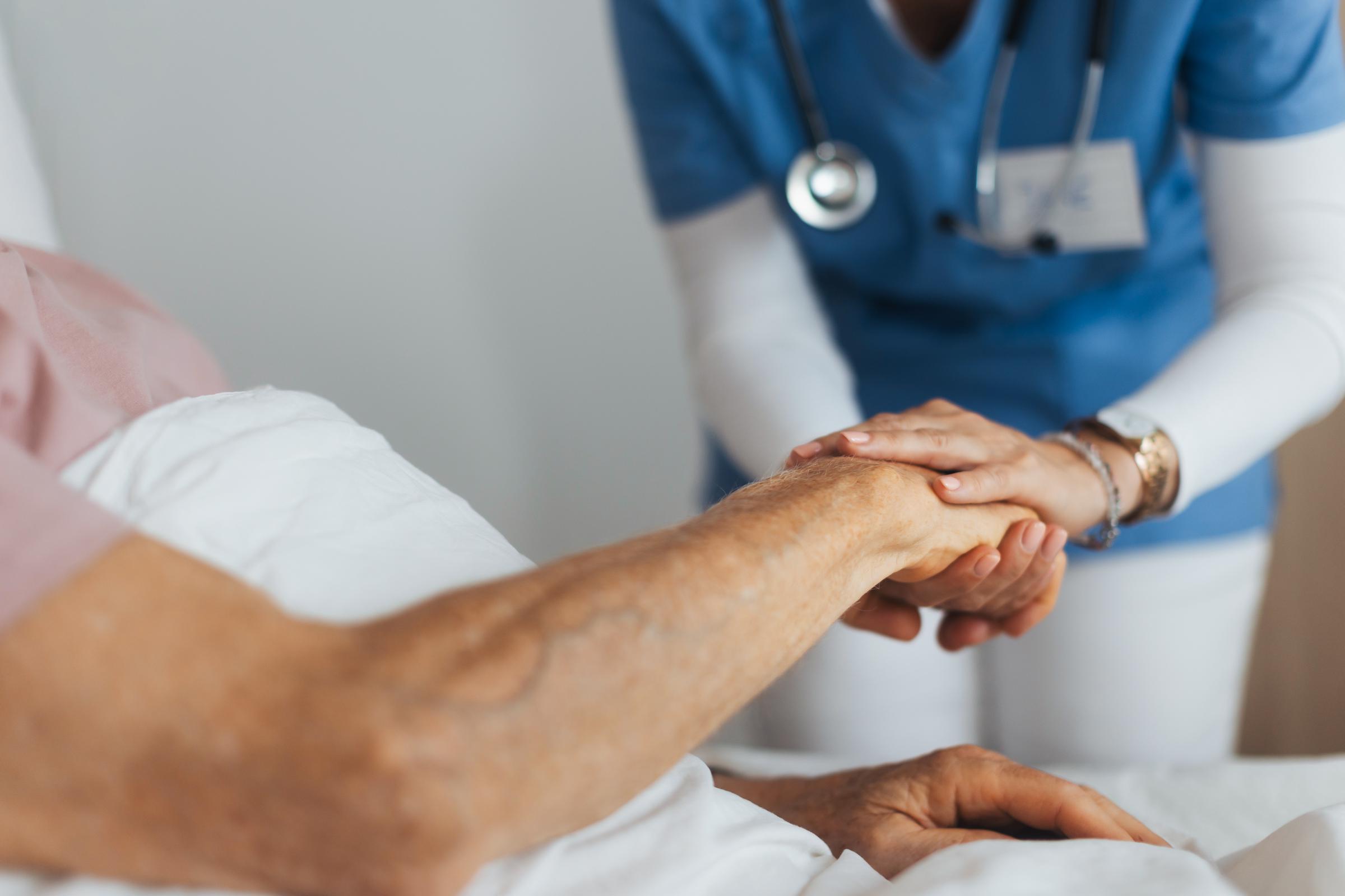 A care giver holding a patient's hand | Source: Getty Images