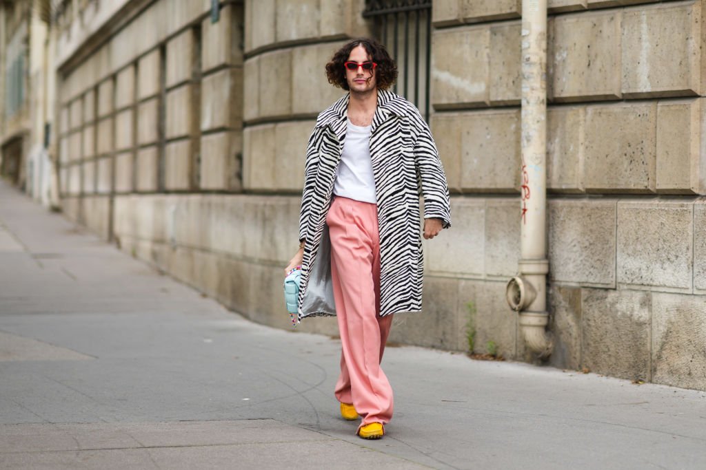 Alejandro Acero in zebra coat, Bottega Veneta handbag, pale pink pants, and yellow loafers at the Paris Fashion Week on June 23, 2021 | Source: Getty Images