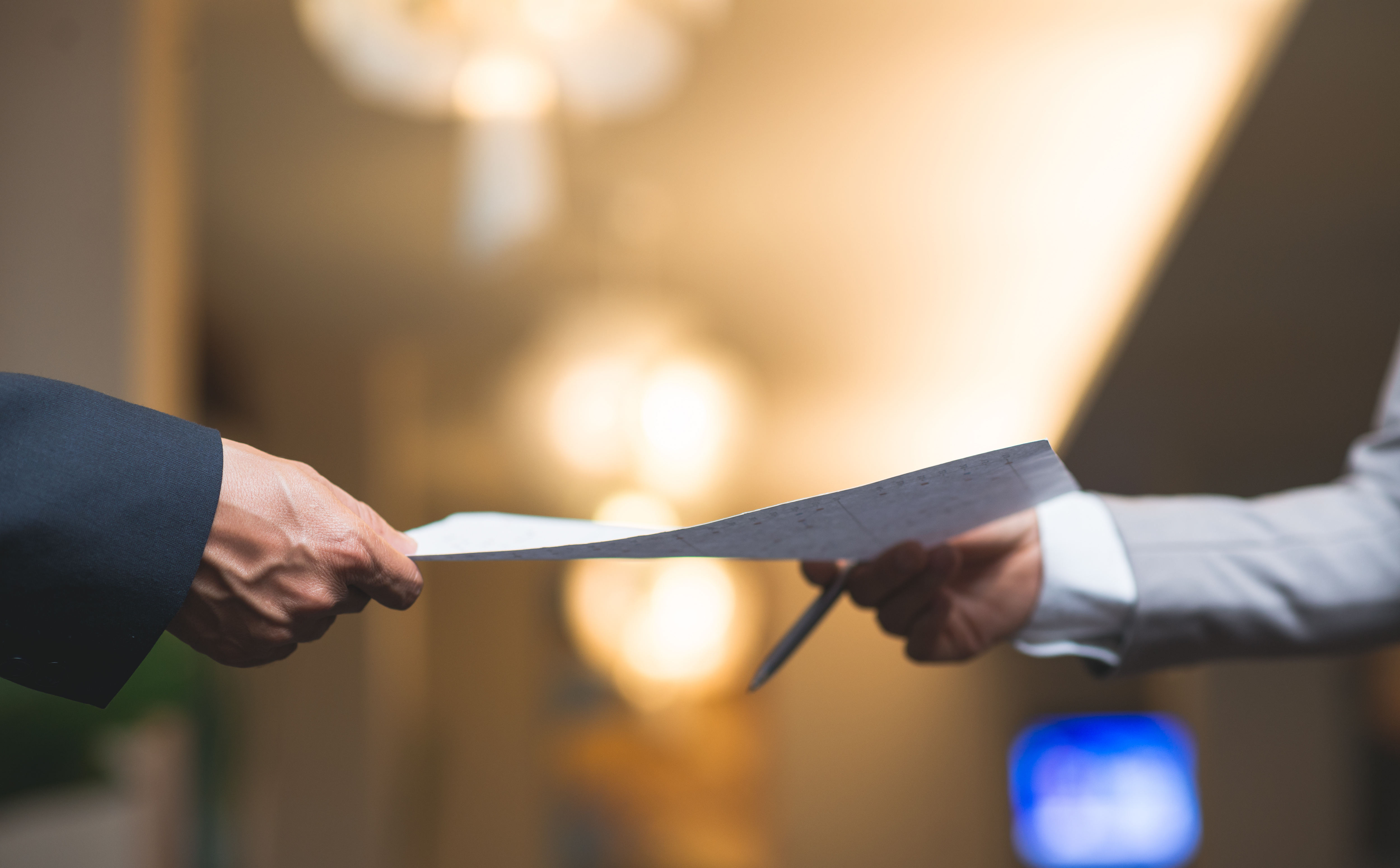 Hands of business people passing document | Source: Shutterstock