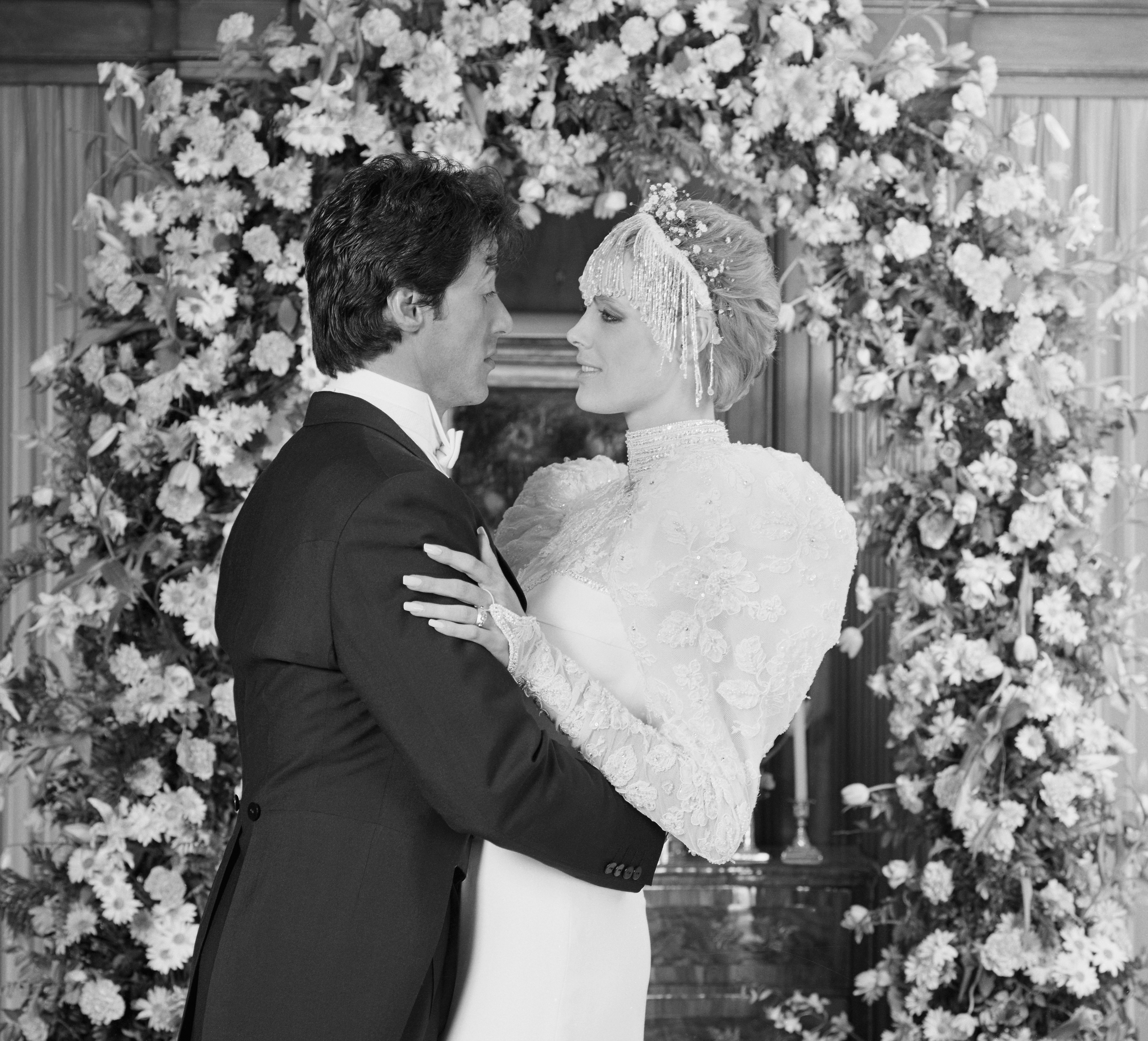 Sylvester Stallone and Brigitte Nielsen sharing an embrace at their wedding at the home of Irwin Winkler, 1985 | Source: Getty Images