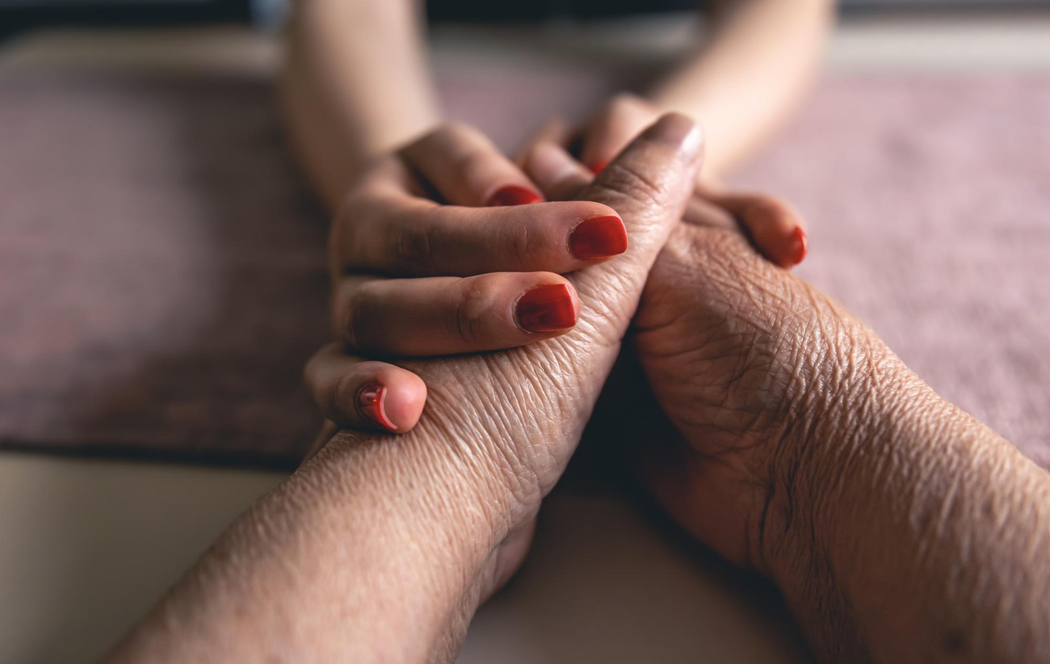 A young woman holding an older person's hands | Source: Freepik