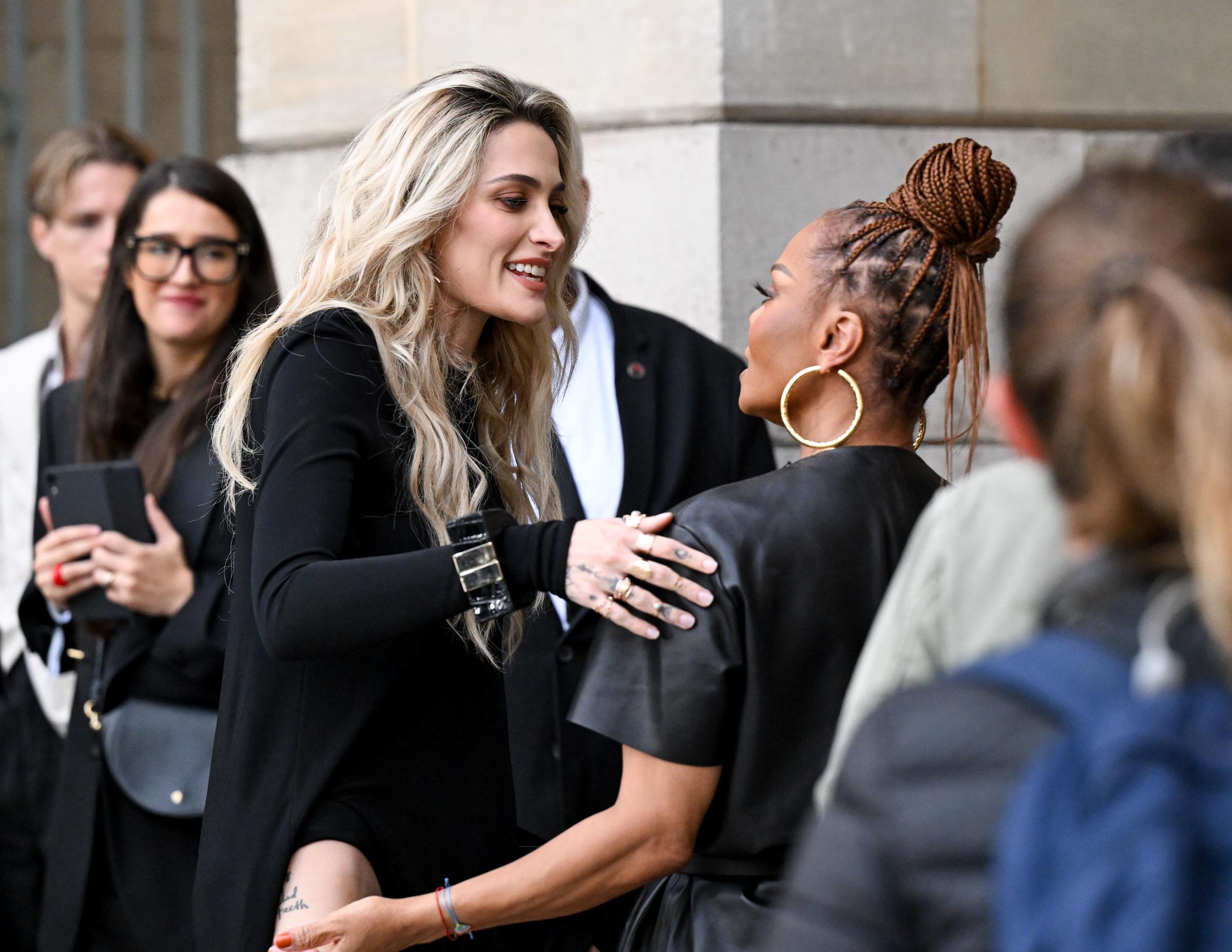 Paris Jackson shares a warm moment with her aunt, Janet Jackson, at the Tom Ford Spring/Summer 2026 show during Paris Fashion Week on October 1, 2025. The two were photographed side by side, their coordinated black ensembles highlighting a rare and heartwarming family appearance in the fashion capital.
