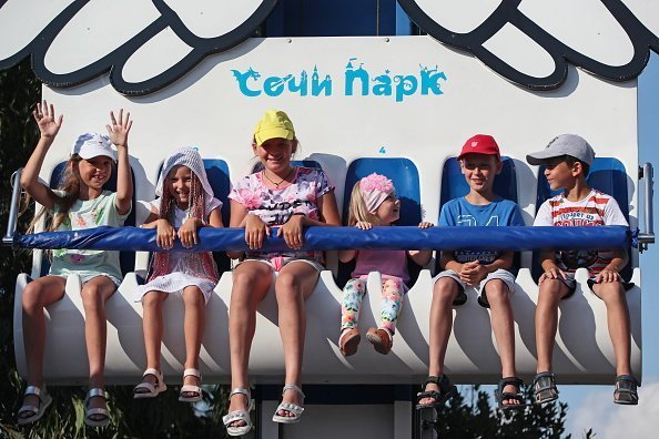 Young children pictured having fun in a drop tower in the Sochi Park amusement park. | Photo: Getty Images