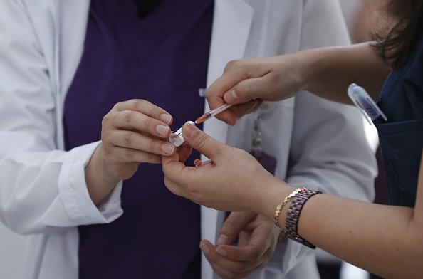 Des passagers et le personnel de la gare reçoivent des doses de vaccins contre le coronavirus (COVID-19). |Photo : Getty Images