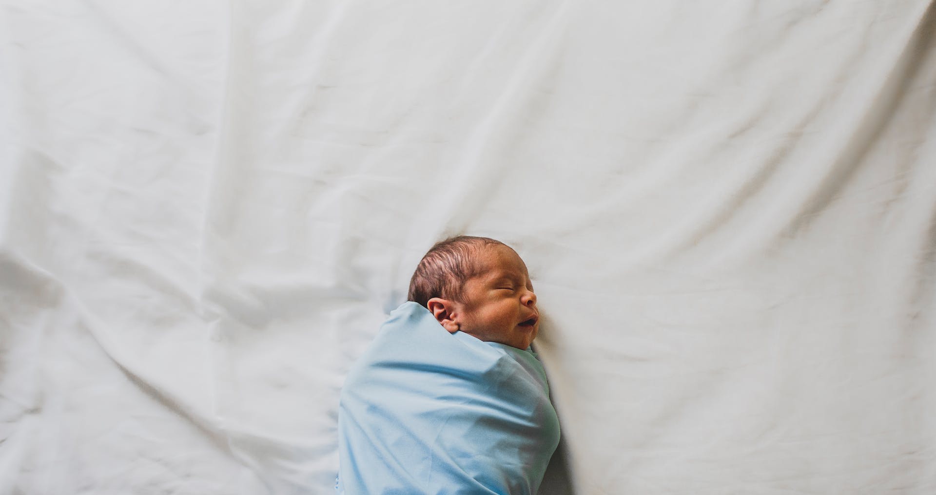 Newborn baby boy wrapped in a blue blanket | Source: Pexels