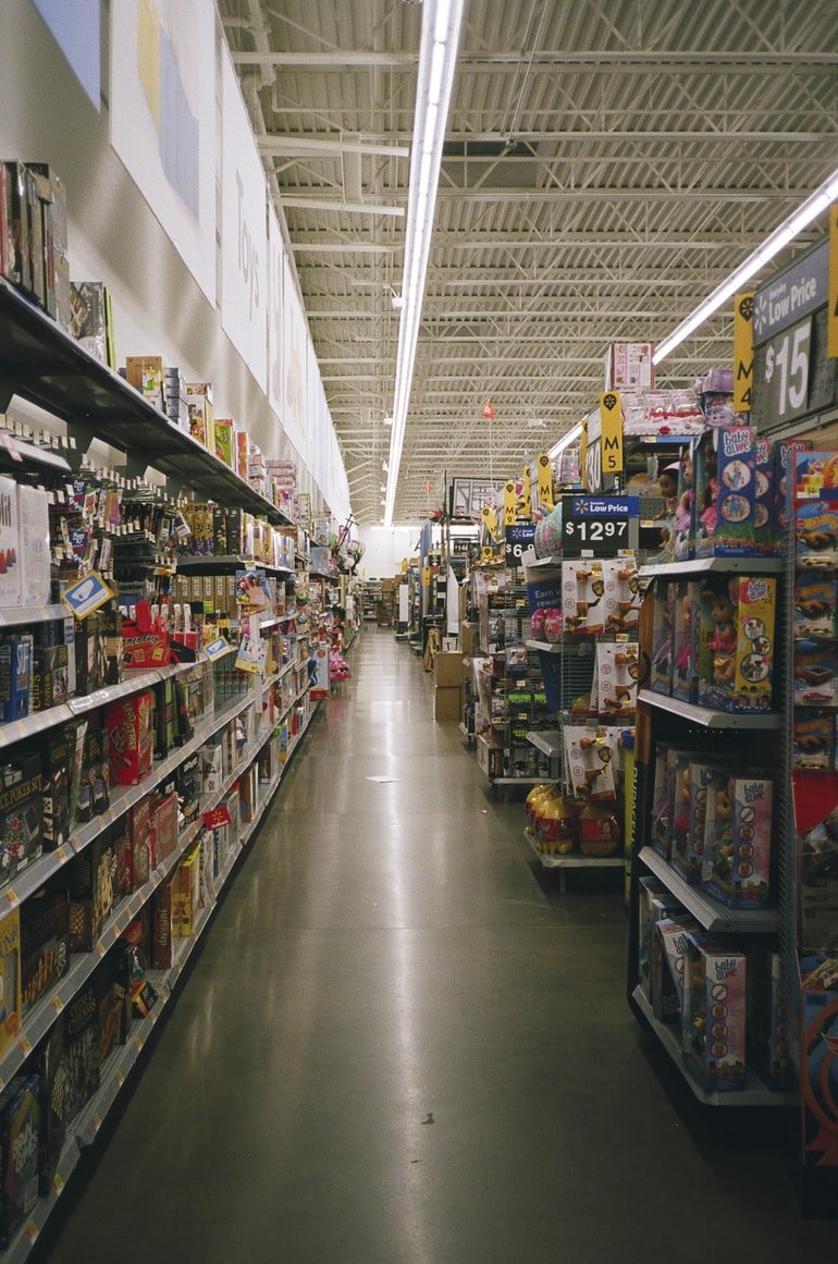 A grocery store with products placed in parallel shelves. | Source: Unsplash