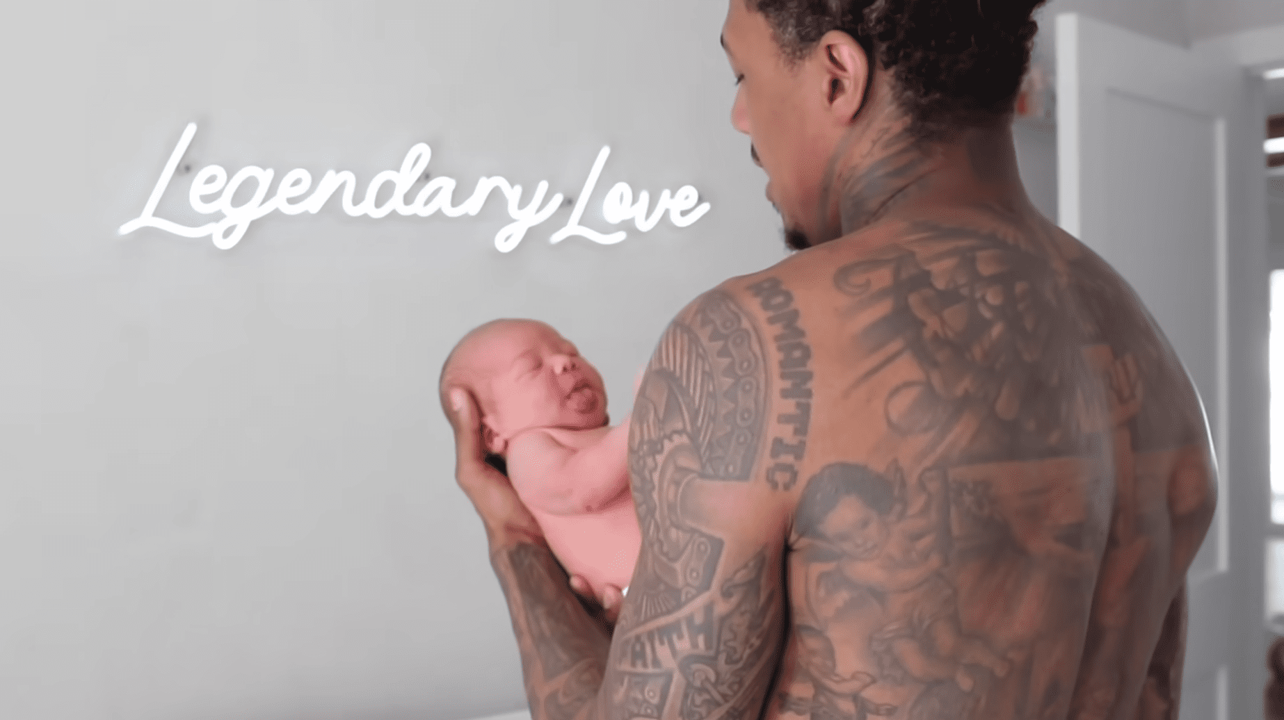 Nick Cannon cradles son Legendary Love Cannon as the infant's name appears onscreen | Source: YouTube.com/BreTiese