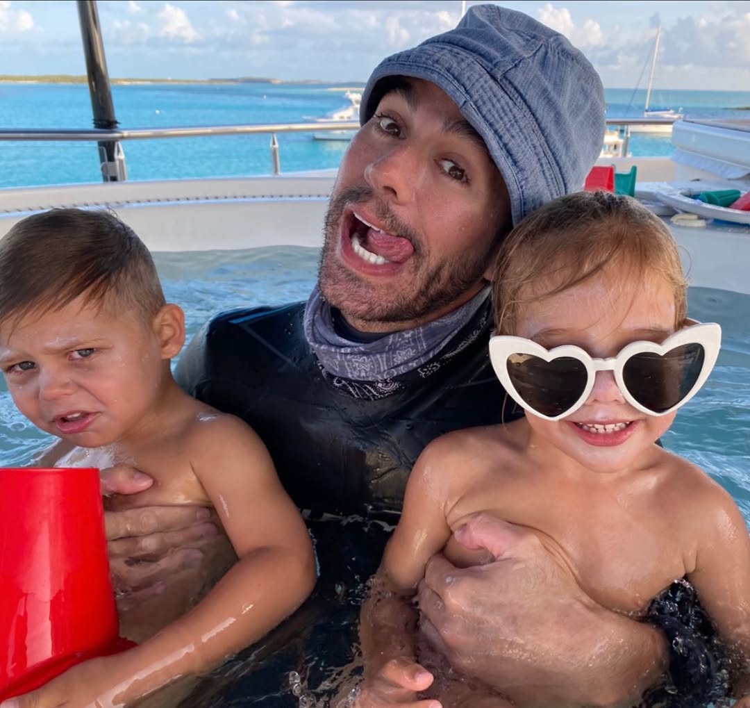 Enrique Iglesias holding Nicholas and Lucy Iglesias in a pool, from a post dated July 4, 2021 | Source: Instagram/enriqueiglesias