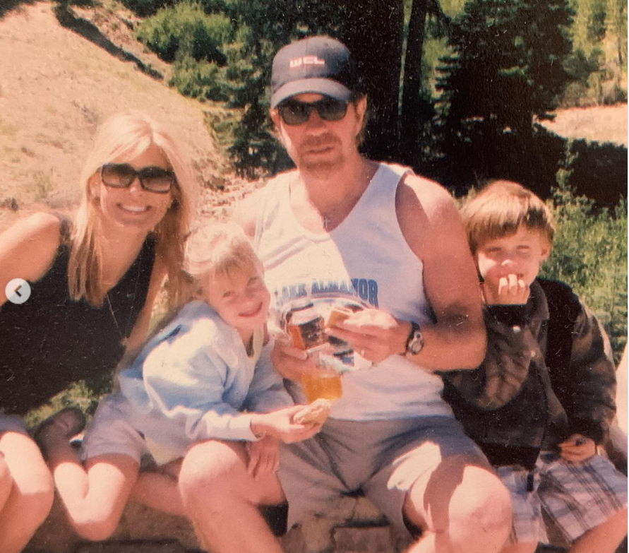 Chuck Norris and Gena O'Kelley Norris sit outdoors with young Danilee Norris and Dakota Norris, sharing a sunlit family moment that feels easy, playful, and full of warmth. | Source: Instagram/chucknorris