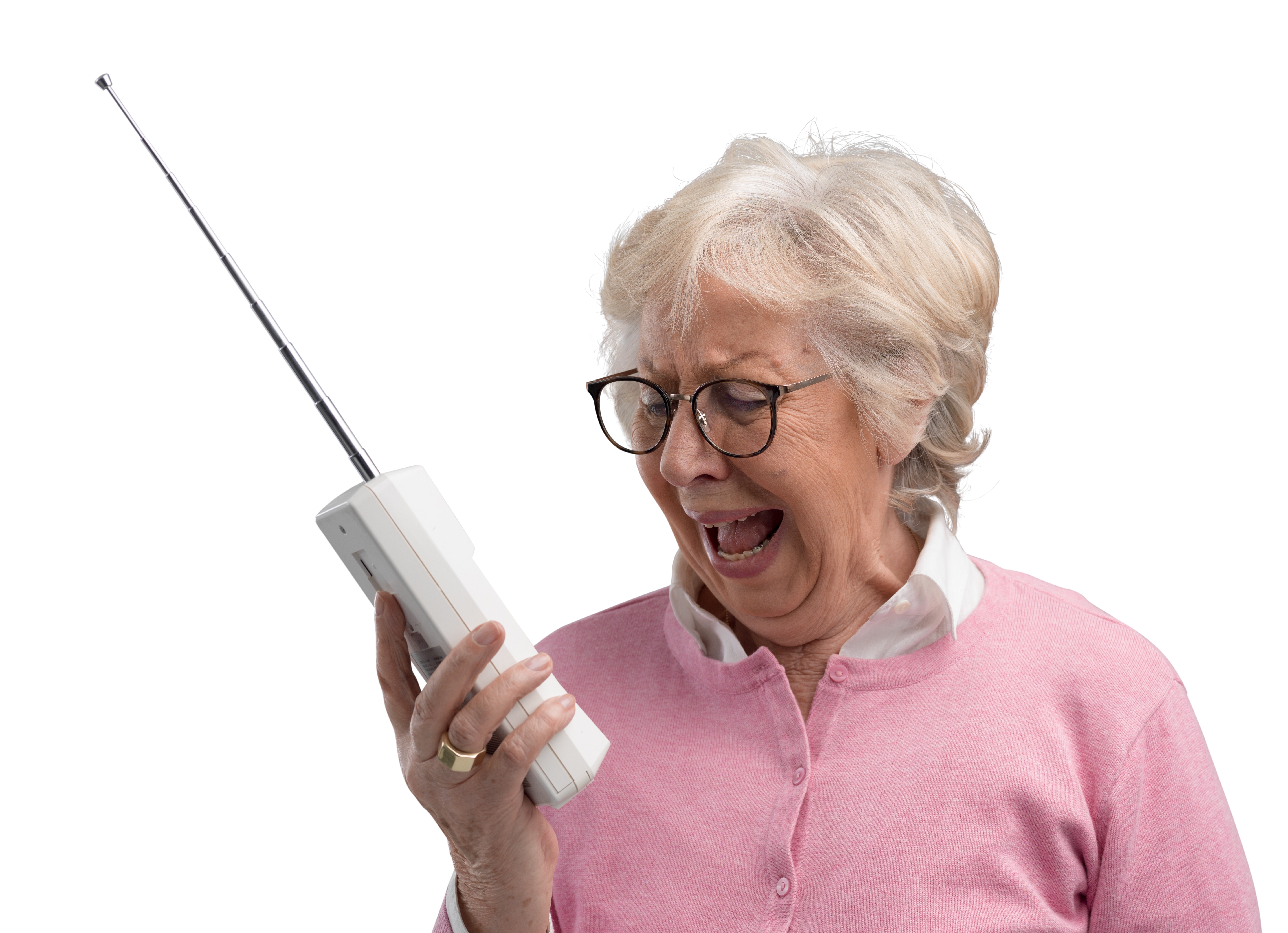 A frustrated senior woman using an old cordless phone | Source: Shutterstock
