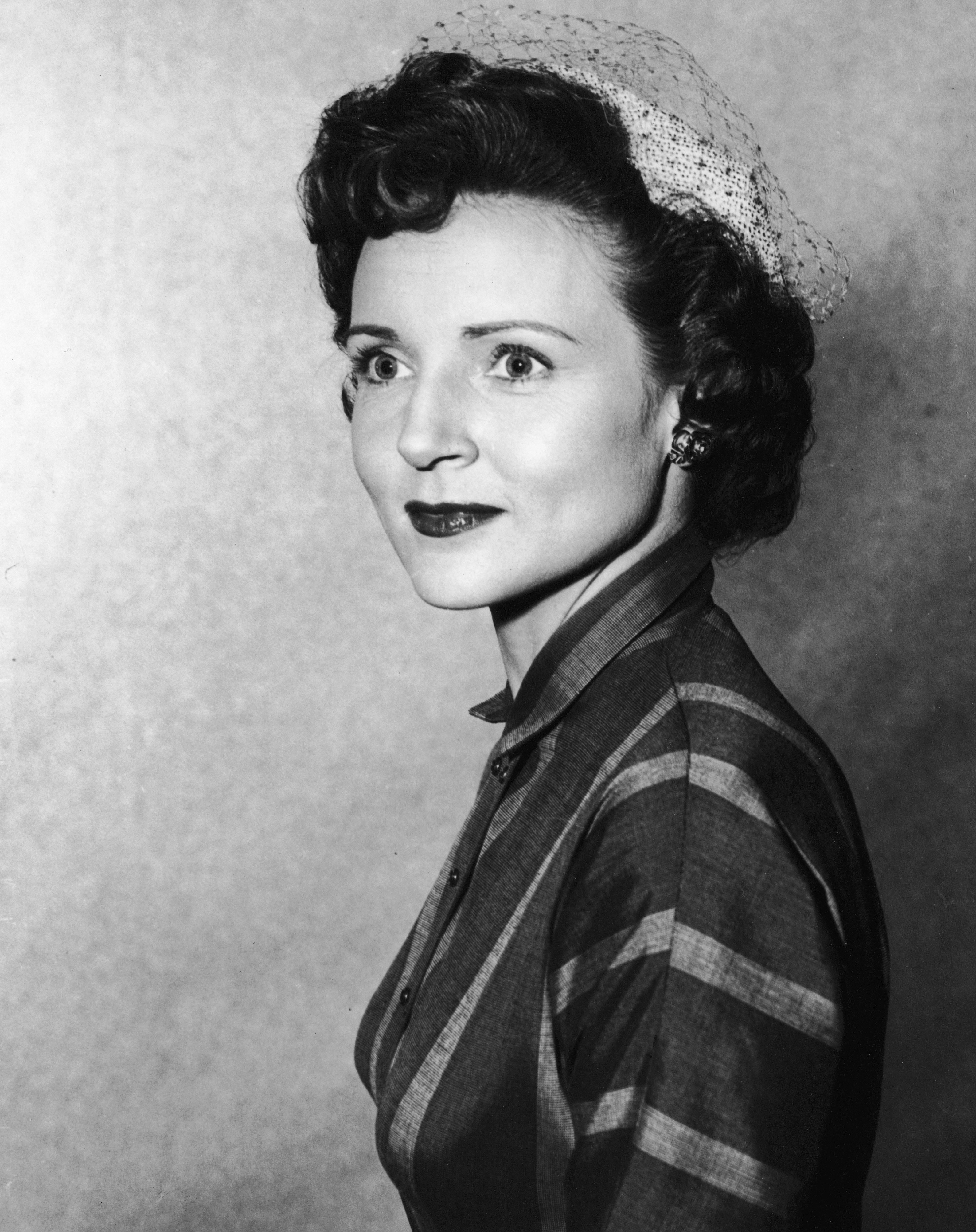 A headshot portrait of Betty White wearing a veiled hat, circa 1955 | Photo: GettyImages