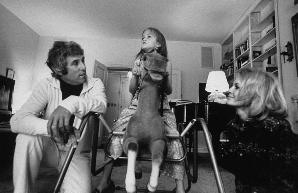 Komponist Burt Bacharach Jr. (L) und seine Schauspielerin Frau Angie Dickinson beobachten ihre Tochter auf einem Schaukelpferd reiten. | Quelle: Getty Images