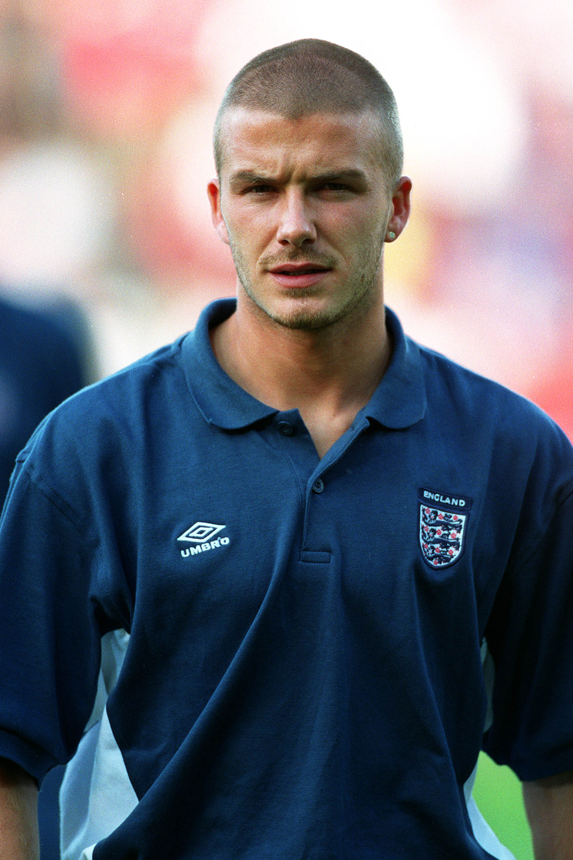 A close-up of David Beckham in his England training kit at Euro 2000 — buzz cut, stud earring, and a trace of stubble, the same chiselled features that fans would later spot on his son decades later.