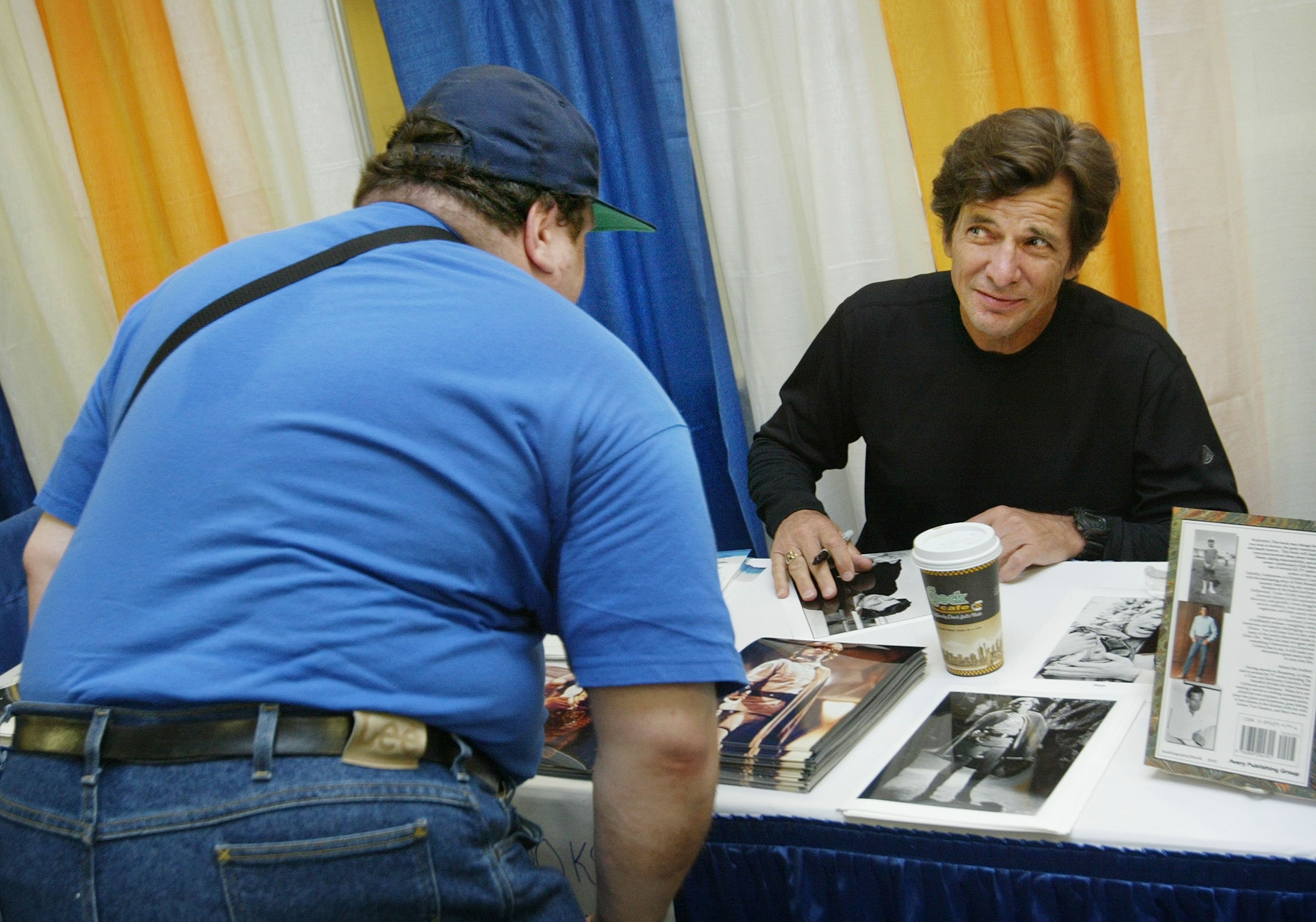  Dirk Benedict talks to a fan at the Sci-Fi and Fantasy Creators Convention June 27, 2003 in New York City. | Photo: Getty Images