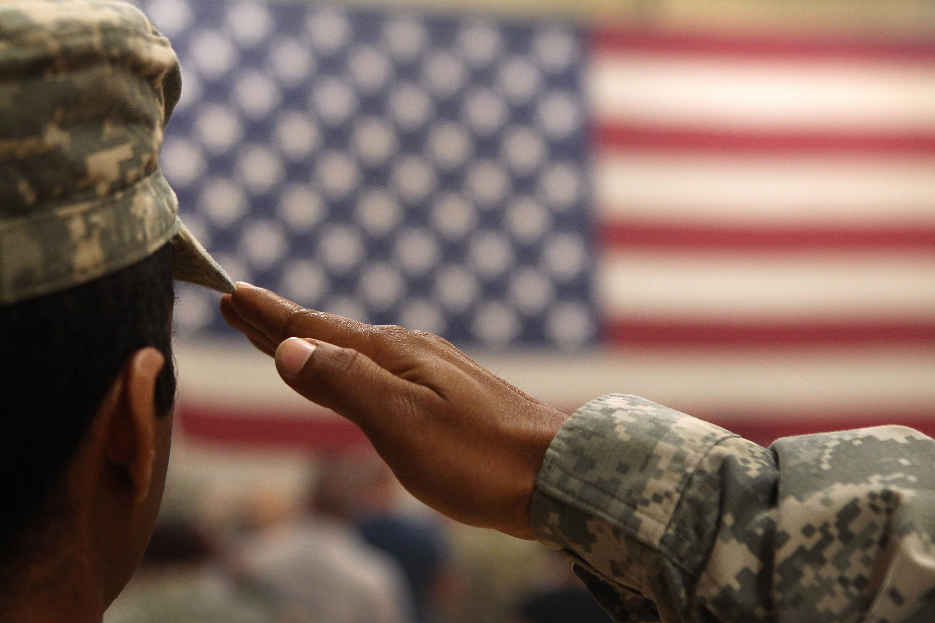 A soldier salutes the flag during a welcome home ceremony. | Photo: Getty Images