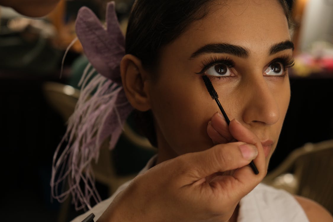 Mujer sentada mientras maquillan sus ojos. | Foto: Pexels Mujer sentada mientras maquillan sus ojos. | Foto: Pexels