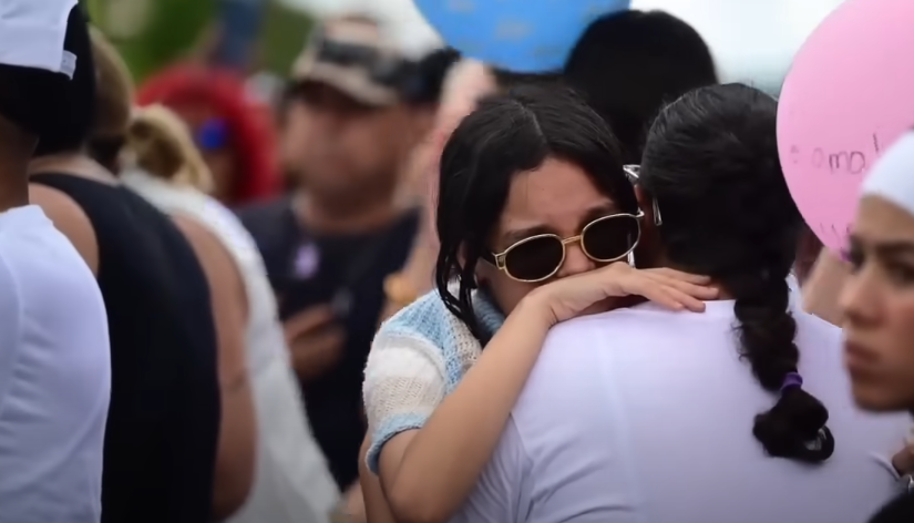 Two women hugging at the funeral procession in honor of Gabriela Nicole Pratts Rosario, from a news reported dated August 15, 2025 | Source: Youtube/El Nuevo Dia