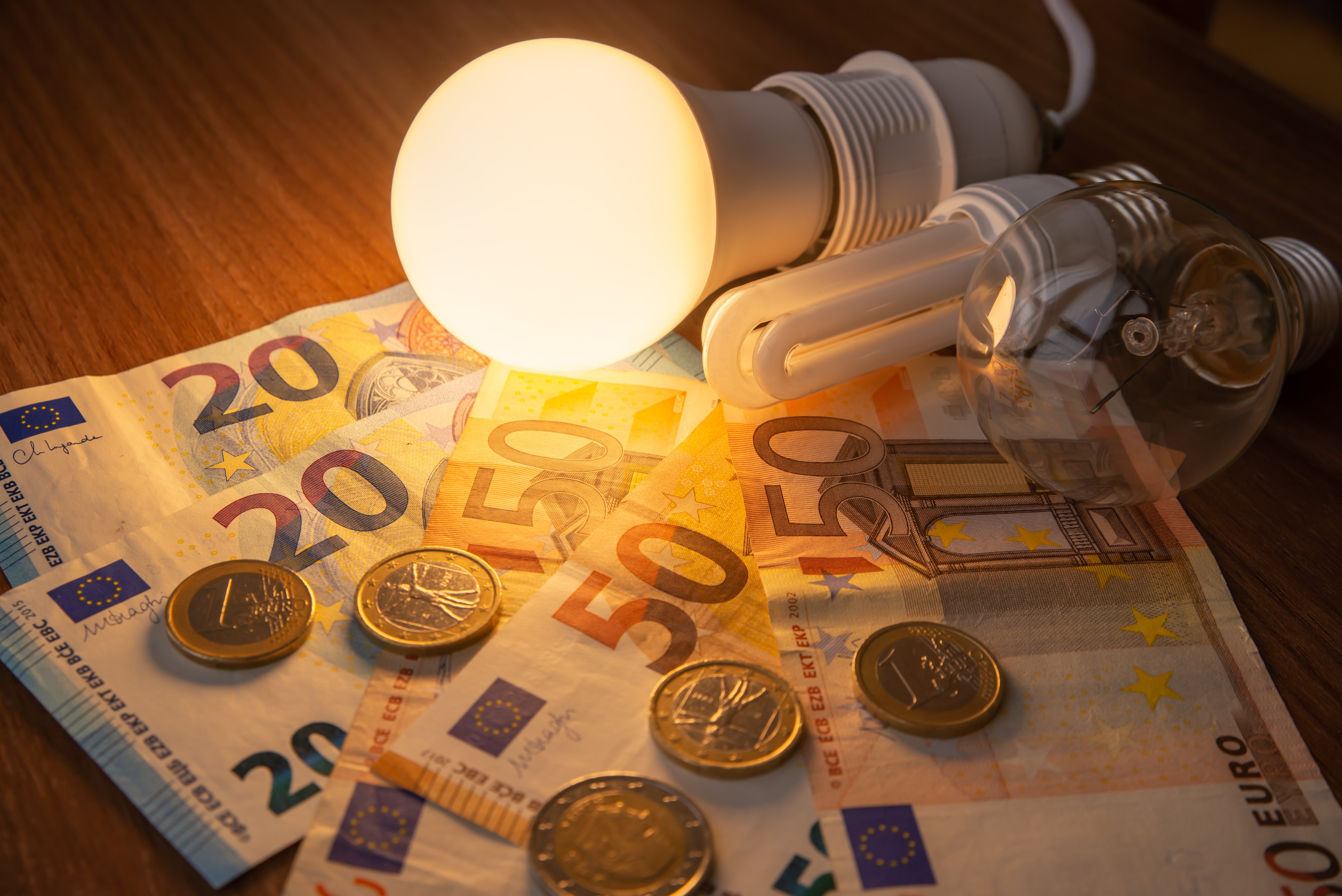 Foco LED y ahorrador sobre pila de dinero. | Foto: Shutterstock