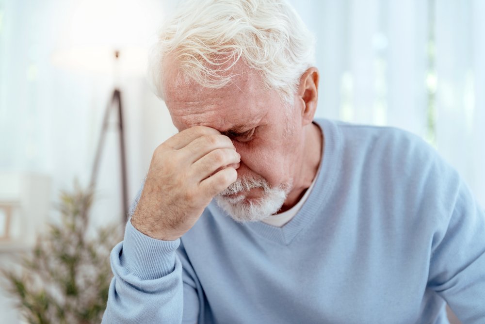 A disappointed senior man covering his face. | Photo: Shutterstock
