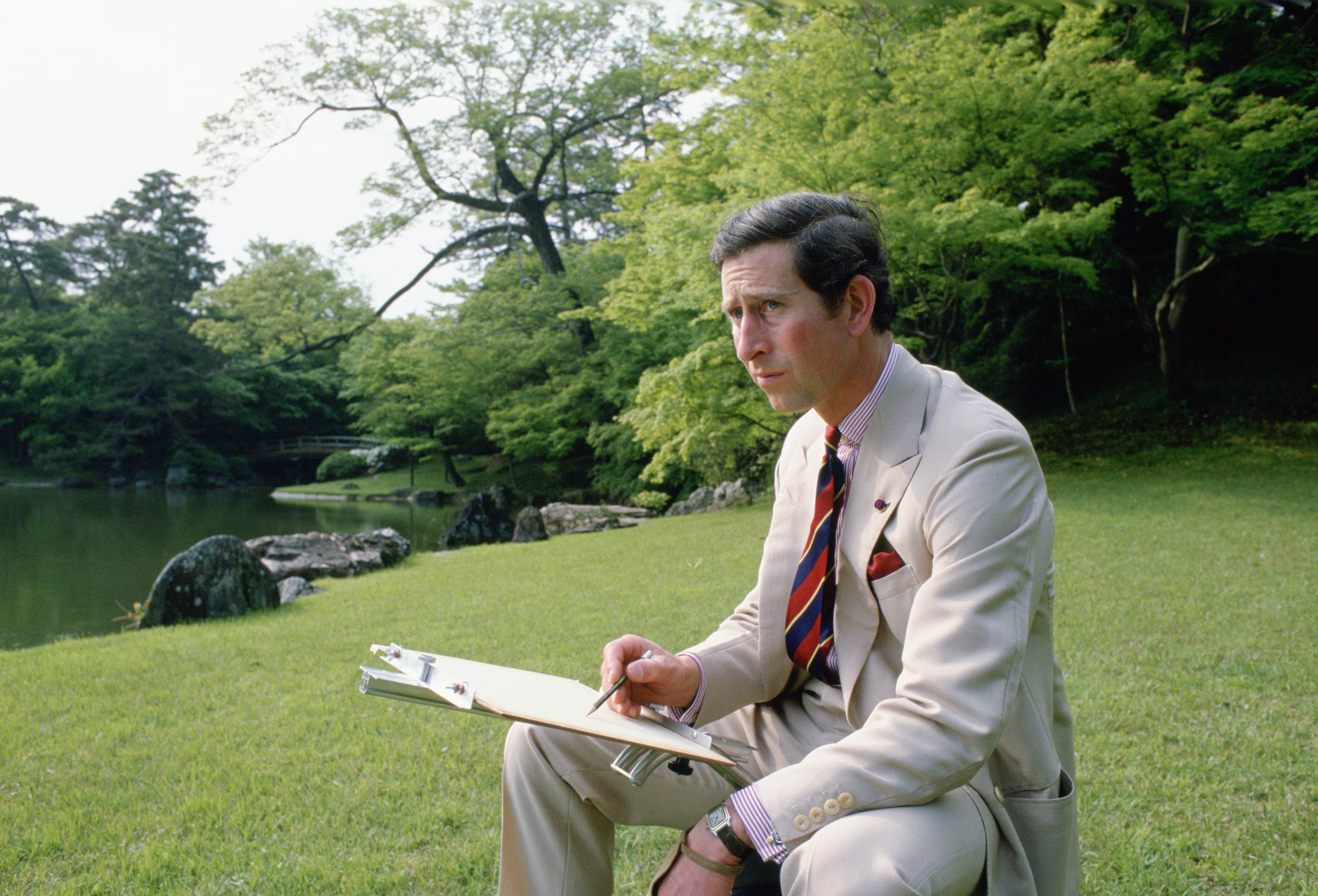 Prince Charles sketching in the gardens of Omiya Palace during a break in his official tour of Japan on May 8, 1986 | Source: Getty Images