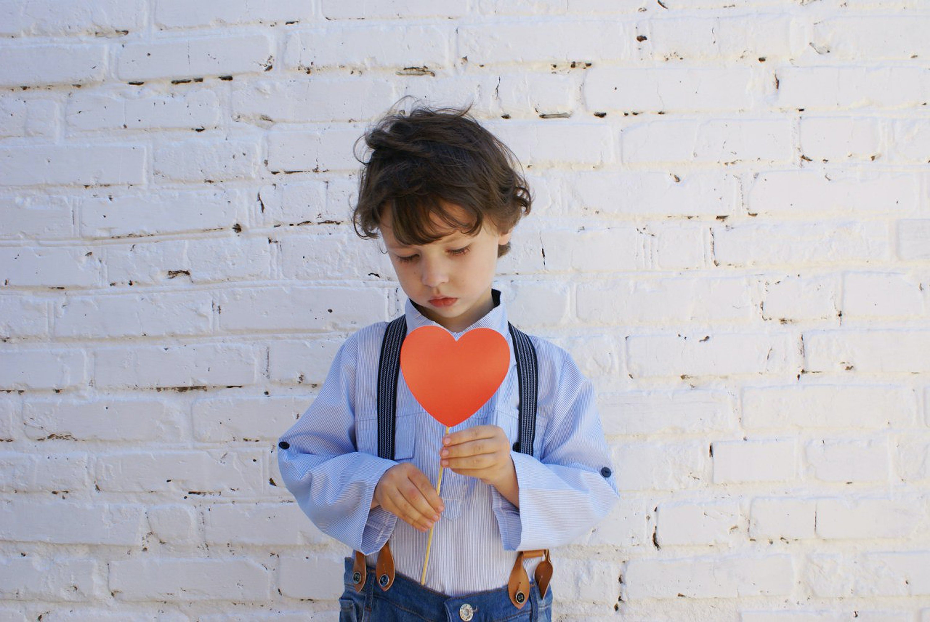 Niño pequeño con un corazón rojo recortado. | Foto: Pexels