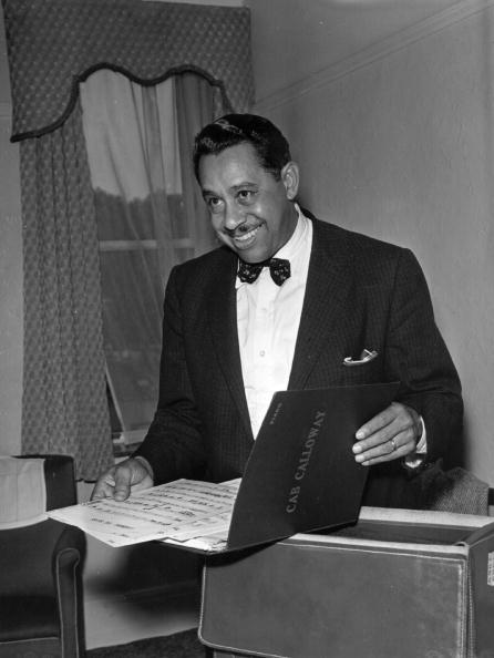 Cab Calloway opening a folio of music news | Photo: Getty Images