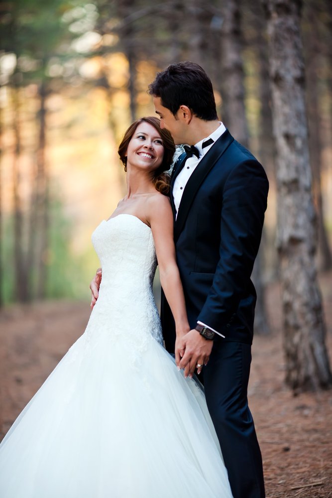 A happy bride and groom at a park on their wedding day. | Photo: Shtterstock.