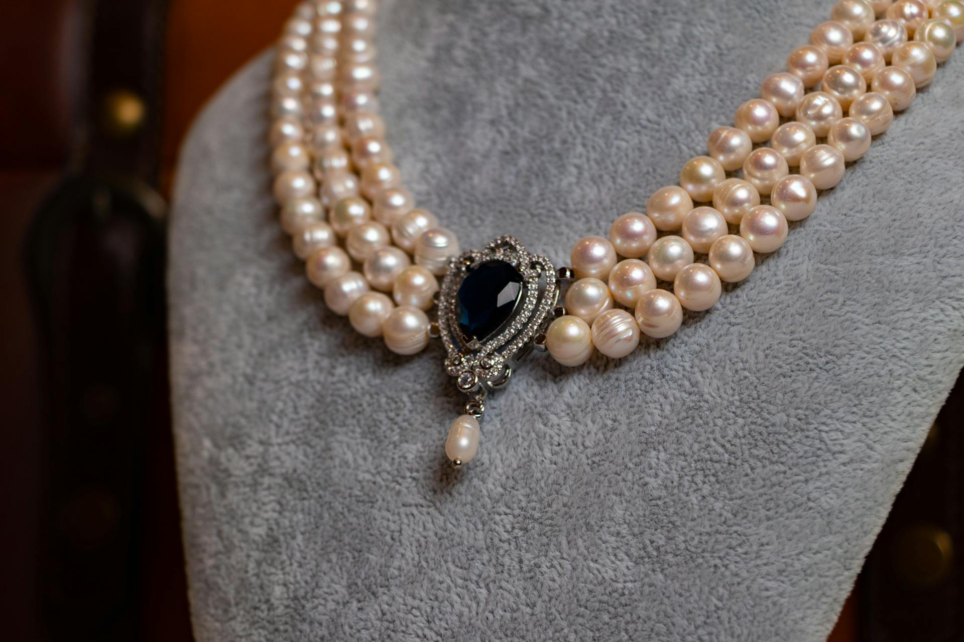 A pearl necklace with a dark gemstone | Source: Pexels
