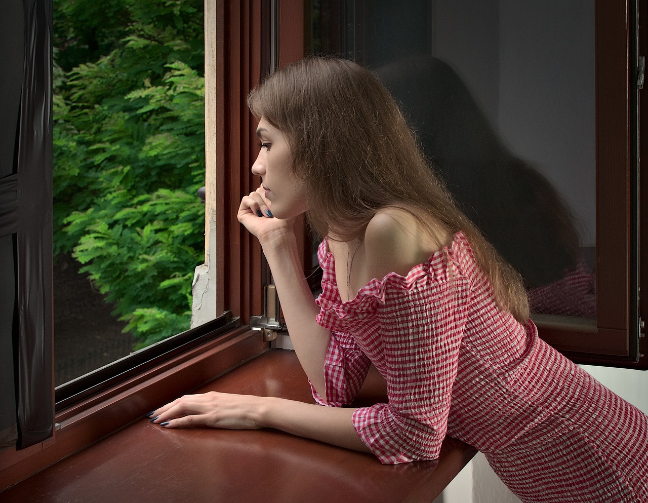 Young woman leaning by the window | Source: Pixabay