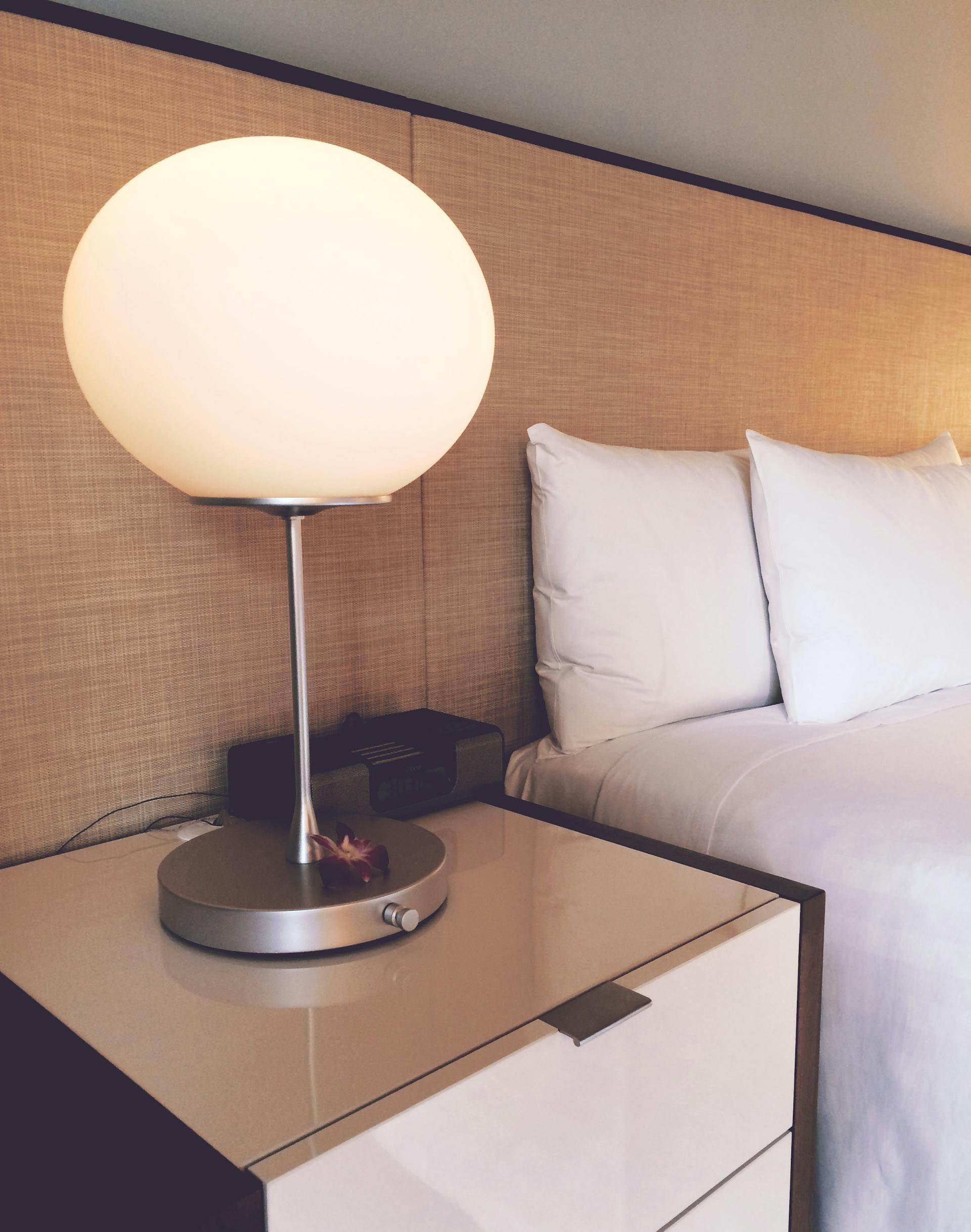 A silver and white desk lamp beside a bed | Source: Pexels