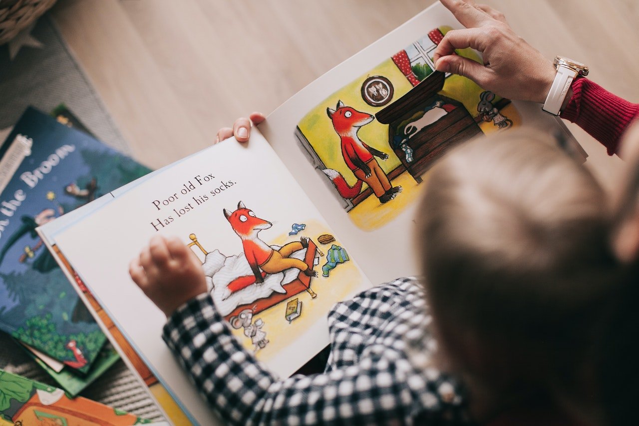 A young child reading a book | Photo: Pexels
