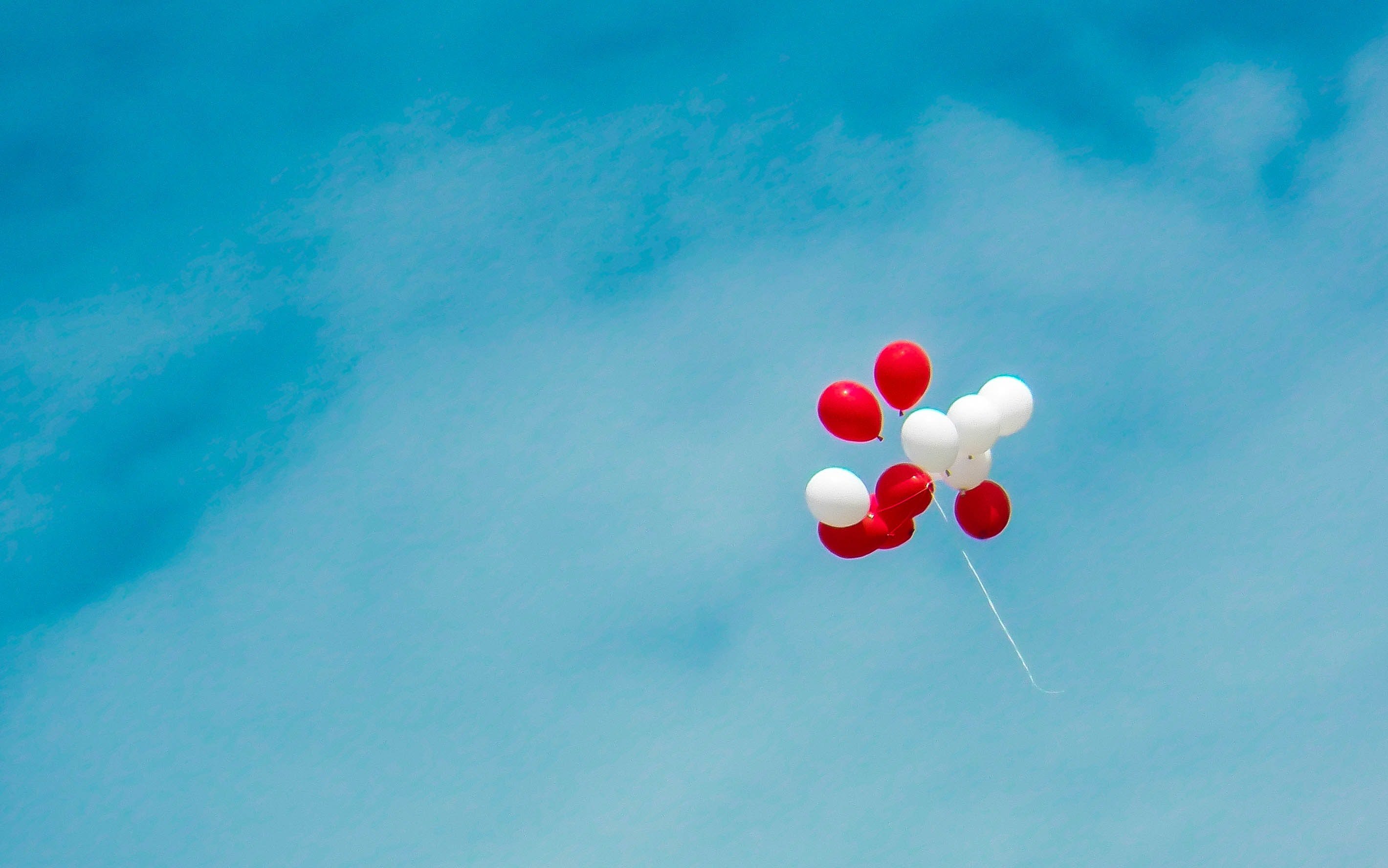 Red and white balloons in the sky. | Photo: Pexels