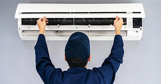 A man fixing an air conditioner | Photo: Shutterstock