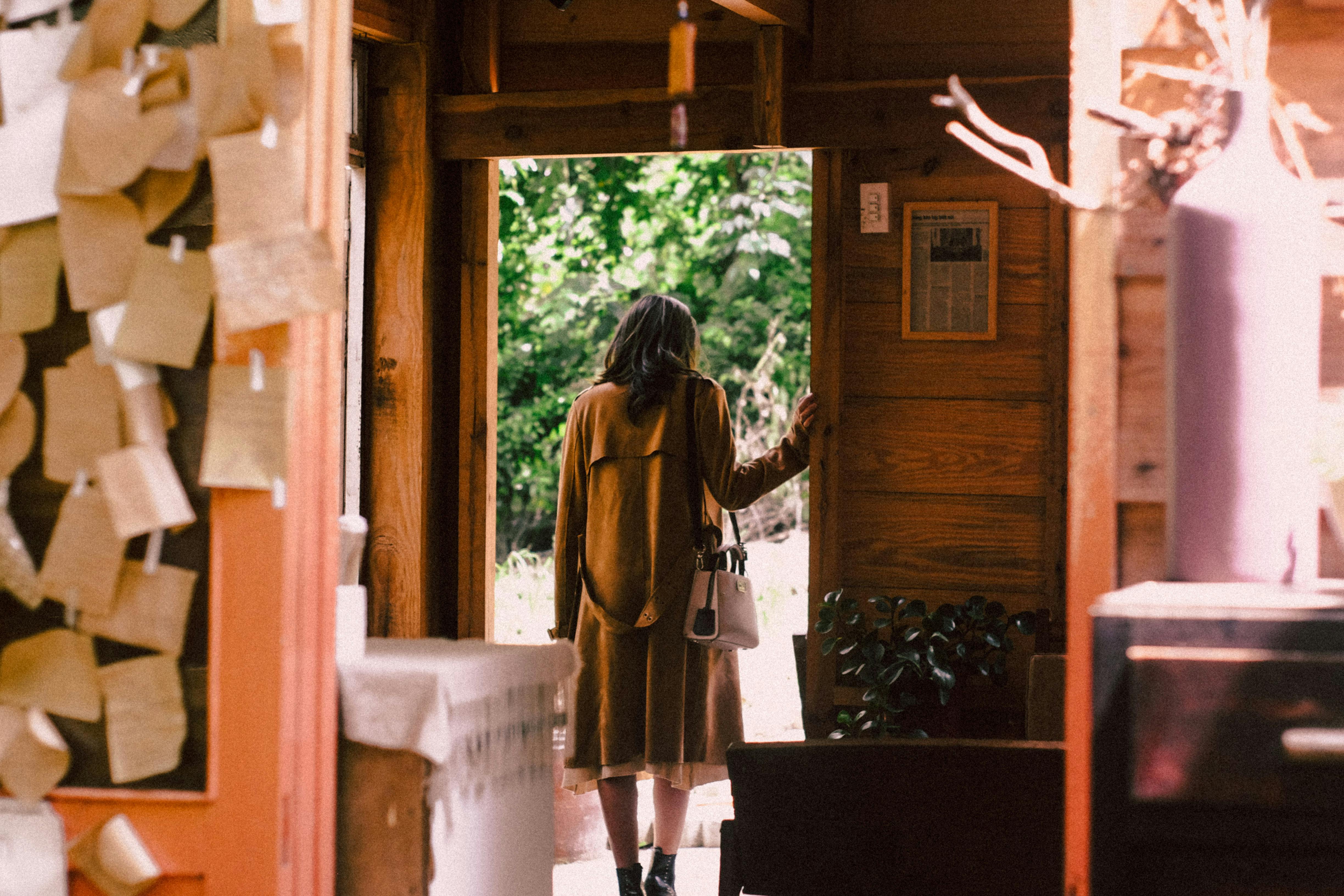 A woman standing near an open door | Source: Pexels