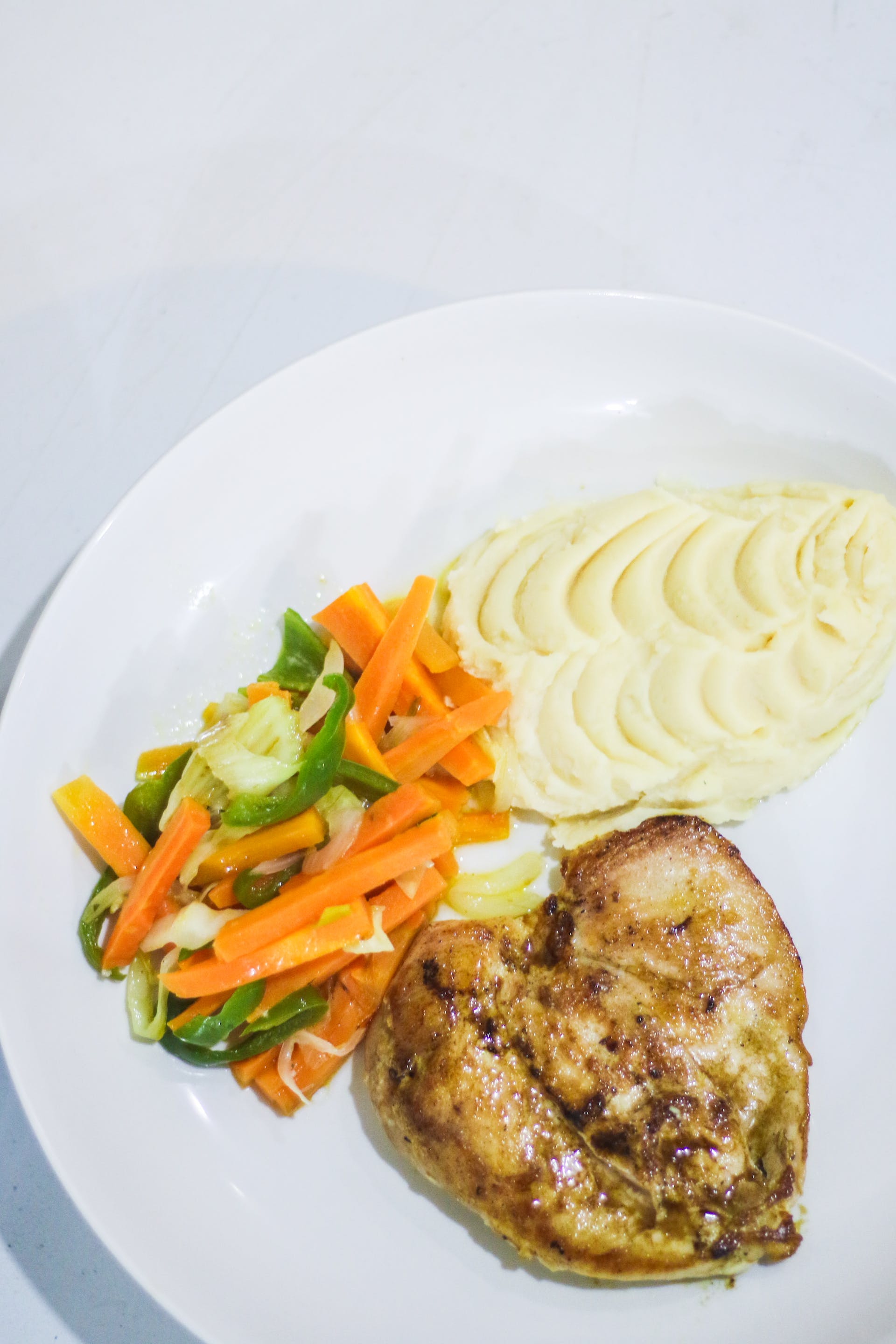 A plate of chicken breast, vegetables, and mashed potatoes | Source: Pexels